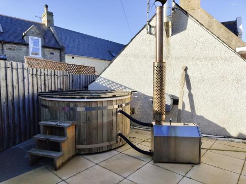 a hot tub on a patio next to a fence at Portknockie 17 Harbour Place Refurbished for 2025 Season in Portknockie