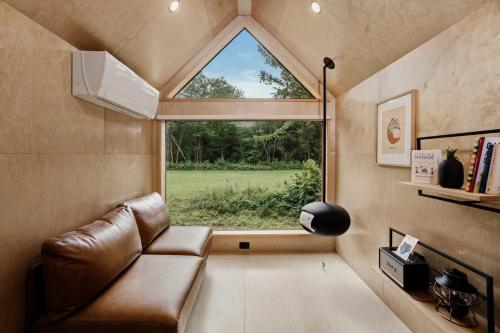 a living room with a couch and a large window at Lumen Nature Retreat in Woodstock