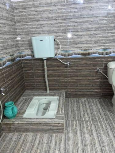 a bathroom with a toilet in the corner of a room at Eagles Nest Muzaffarabad in Muzaffarabad