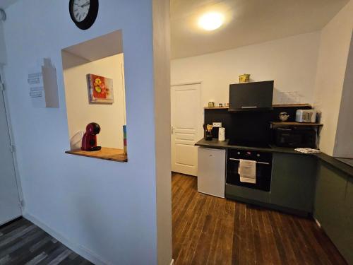 a kitchen with a counter and a stove in a room at T2 cosy in Guéret