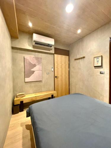 a bedroom with a bed and a air conditioner at 在覺樂禪意文旅-訂房後須聯繫轉帳 in Tainan