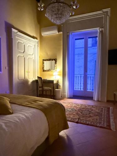 a bedroom with a bed and a door and a table at Palazzo Dogana Room&Suite in Salerno