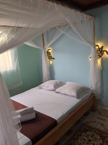 a bedroom with a bed with a canopy at Le DIEGO Hôtel in Antsiranana