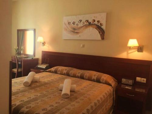 Una habitación de hotel con una cama con toallas. en Nefeli Hotel, en Agios Kirykos