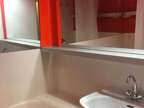 une salle de bain avec un lavabo et un miroir dans l'établissement Duplex tranquille · Proche des pistes · Balcon · WiFi · Parking - FR-1-346-430, à Arc 1800