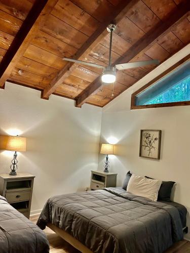 a bedroom with two beds and a wooden ceiling at Cedar Wood Lodge Wkayaks & Canoes, Outdoor Dining in Karnack