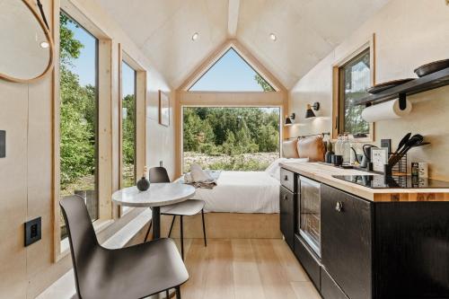 a kitchen with a table and a bedroom with a bed at Lumen Nature Retreat in Woodstock