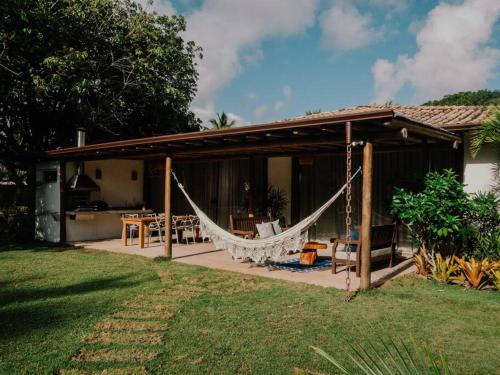 a patio with a hammock and a house at Casa Caetano - Peninsula de Maraú - Taipus de Fora in Taipu