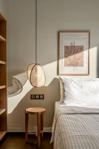 a bedroom with a bed and a pendant light at Coco-Mat Efterpi House by Plakias Suites in Plakias