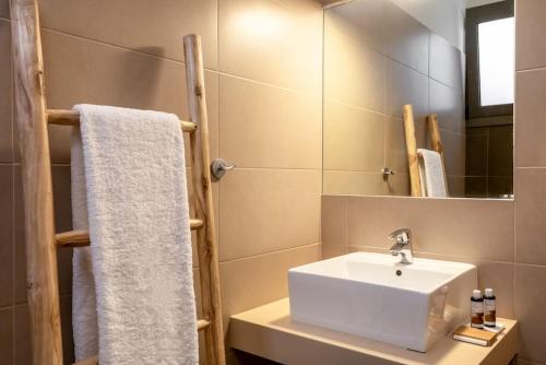 a bathroom with a white sink and a mirror at Coco-Mat Efterpi House by Plakias Suites in Plakias
