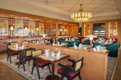 a restaurant with tables and chairs and a chandelier at Ocean Eden Bay - Adults Only - All Inclusive in Falmouth