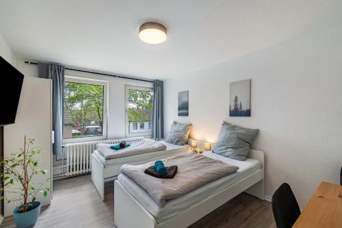 Un dormitorio con dos camas y una ventana. en Zuhause für die Entdeckergruppe, en Dinslaken