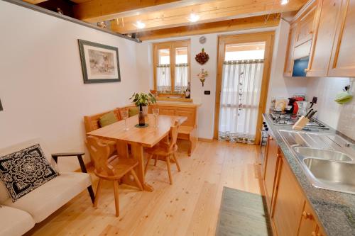 a kitchen and dining room with a wooden table at Borgo Nuovo Deluxe con garage box in Forni di Sopra
