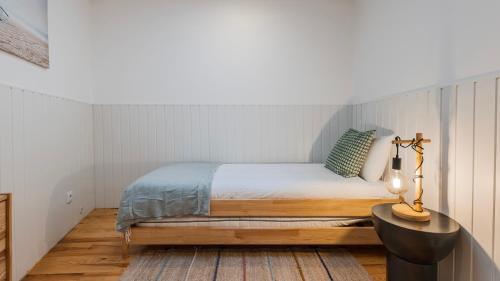 Un dormitorio con una cama, una lámpara y una mesa. en Pátio Vilareto - Villa Clara, en São Domingos de Rana