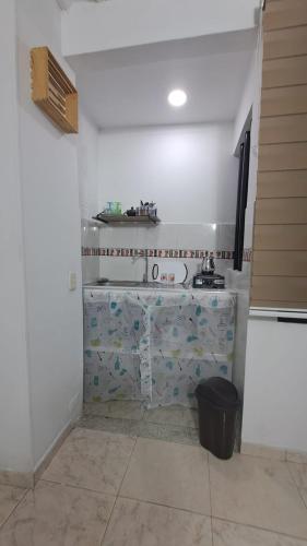una cocina blanca con encimera y cubo de basura en Apartaestudio Con Entrada Independiente, en Ibagué
