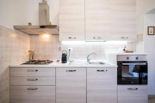 a kitchen with white cabinets and a sink and a stove at Casa Belfiore in Florence