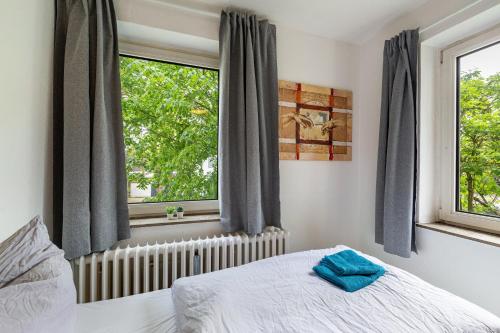 a bedroom with a bed and two windows at Urbanes Nest, ideal für Entdecker in Dinslaken