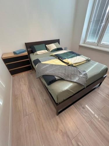 a large bed in a room with a wooden floor at Apartment Česká 23 in Koliba