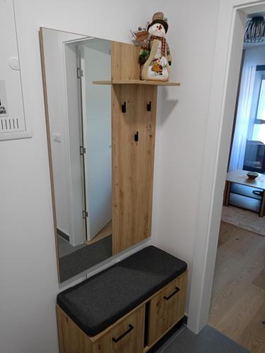 a dressing room with a mirror and a stool at A-Apartman in Bjelašnica