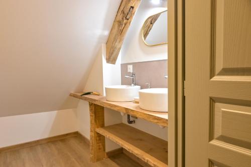 a bathroom with two sinks and a mirror on a counter at Les Longères de Montfranc - Gîte in Pierrefitte-sur-Sauldre