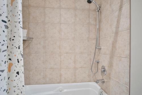 a bathroom with a shower with a white tub at Aiglon by Rendez-Vous Mont-Tremblant in Mont-Tremblant