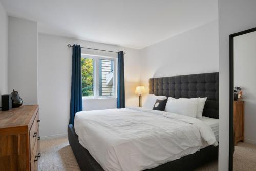 a bedroom with a large bed and a window at Aiglon by Rendez-Vous Mont-Tremblant in Mont-Tremblant