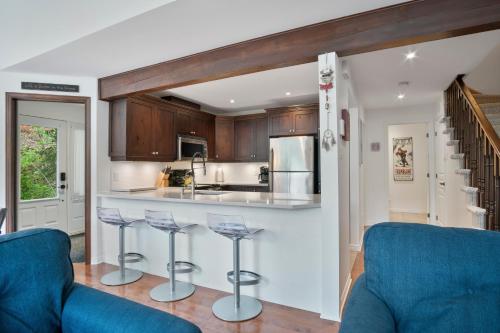 a kitchen with two blue chairs and a counter at Aiglon by Rendez-Vous Mont-Tremblant in Mont-Tremblant
