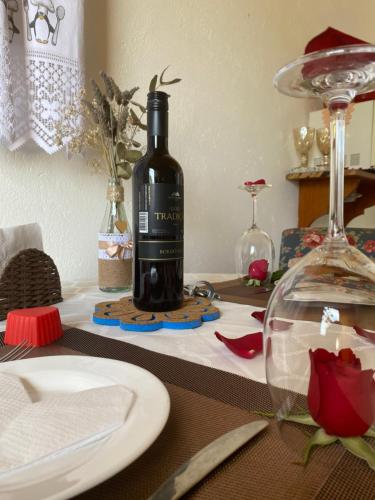 a bottle of wine sitting on top of a table at Casa Aconchegante na Montanha in Campos do Jordão
