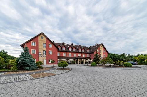 a large red building with a tree in front of it at Hotel Fero Express POKOJE KLIMATYZOWANE AC in Kraków
