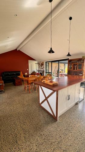 a large kitchen with a large wooden counter in a room at Kohanga Farmstead in Te Kohanga