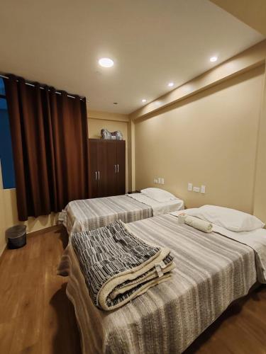 a room with two beds with towels on them at Hotel Sol de Marcona in San Juan de Marcona