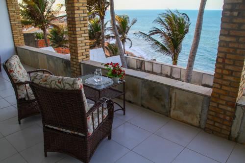 a table and chairs with a view of the ocean at Casa Vista ao Mar - Paisagem Deslumbrante e Localização Perfeita in Canoa Quebrada