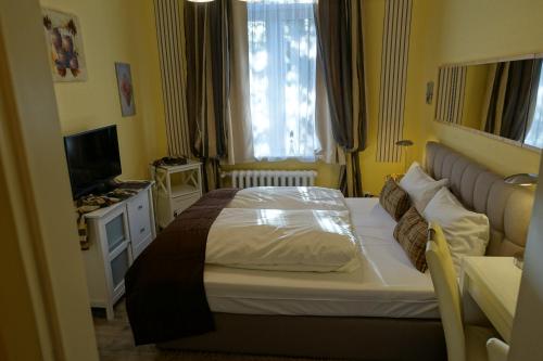 a bedroom with a large bed and a television at Hotel Villa Konstanz in Berlin