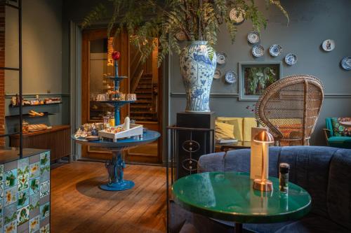 ein Laden mit einer blauen Couch, einem Tisch und einer Vase in der Unterkunft Boutiquehotel Staats in Haarlem