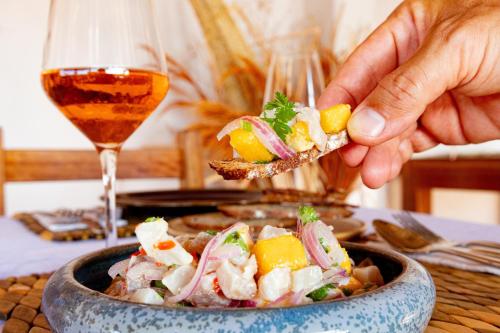 a person holding a piece of food in a bowl at Hurricane Jeri in Jericoacoara