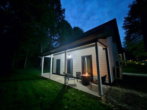 a tiny house with a porch at night at Life's Good Retreat Bear Cottage in Brevard