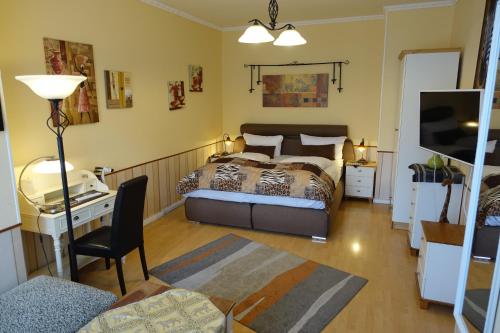 Schlafzimmer mit einem Bett, einem Schreibtisch und einem Stuhl in der Unterkunft Hotel Villa Konstanz in Berlin