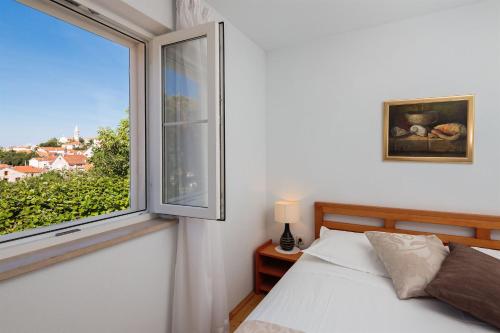 a bedroom with a bed and a large window at House Andre in Nerežišća