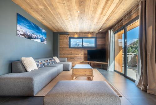 un salon avec un canapé et une télévision dans l'établissement Appartement Les Myrtilles - pied des pistes - 10 personnes, à Les Deux Alpes