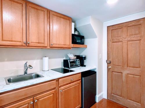 a kitchen with wooden cabinets and a sink and a microwave at Copley House in Boston