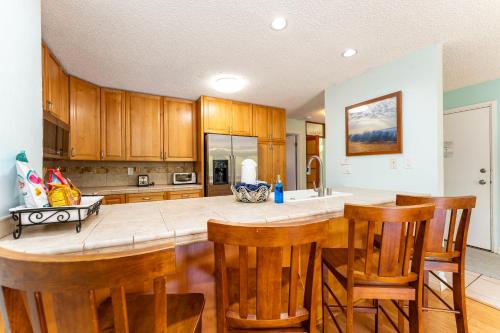 a kitchen with a large island with wooden cabinets at Your Maui Getaway-Walk to the Beach, Pool, Hot Tub LSV14 in Kihei