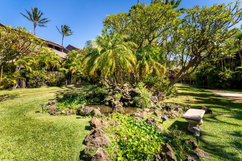 a park with a bench in the grass at Your Maui Getaway-Walk to the Beach, Pool, Hot Tub LSV14 in Kihei