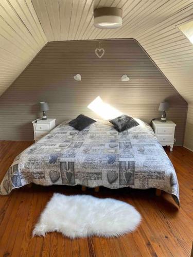 une chambre avec un lit avec deux tables de nuit et deux lampes dans l'établissement Gîte Bihan 4P piscine ou jacuzzi, à Saint-Évarzec