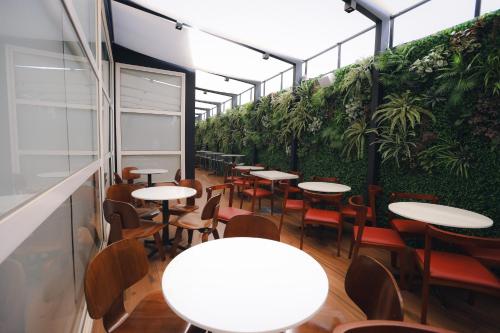 a room with tables and chairs and a green wall at ibis Recife Boa Viagem in Recife