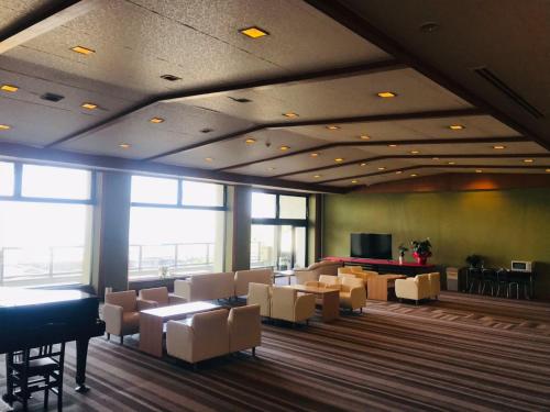 a waiting room with tables and chairs and a piano at Hotel Kaishunro - Vacation STAY 54369v in Hamamatsu