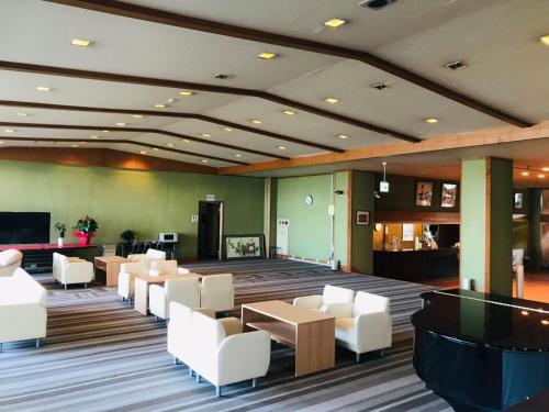 a lobby with a waiting room with white chairs and tables at Hotel Kaishunro - Vacation STAY 54369v in Hamamatsu