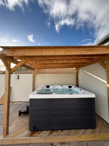 a hot tub on a deck with a wooden pergola at Lyla's at Botany Bay in Broadstairs