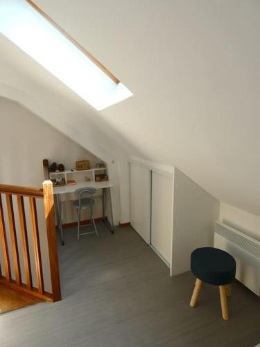 Cette chambre est dotée d'un escalier avec une chaise et un bureau. dans l'établissement Maison en triplex au centre-ville de Cherbourg, à Cherbourg en Cotentin