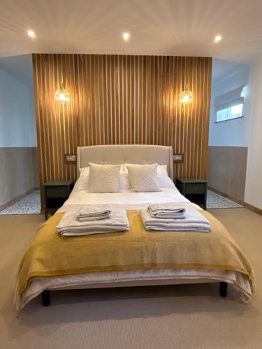 a bedroom with a bed with two towels on it at Lyla's at Botany Bay in Broadstairs