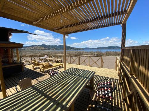 a patio with a table and chairs on a deck at Vichuquen Lodge y Marina in Vichuquén